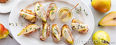 Pear and prosciutto little crostini appetizers, served with honey and thyme. Stock Photo