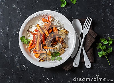 Pearl barley with caramelized baked carrots and onions. Autumn vegetarian buddha bowl. On a dark background Stock Photo