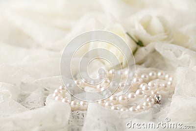 Pearl necklace on lace clothes background. Stock Photo