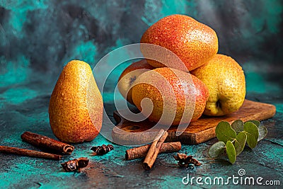 Pears on a dark background. Fresh, ripe fruits on a blue plate and in a box. Healthy eating Stock Photo