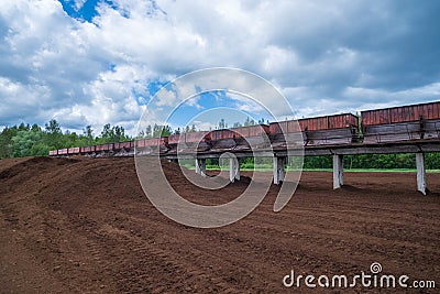 peat transport wagons at the loading point. Raised platform for loading and unloading peat Stock Photo