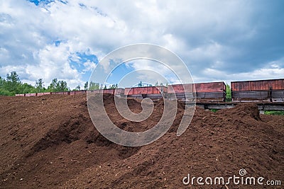 peat transport wagons at the loading point. Raised platform for loading and unloading peat Stock Photo