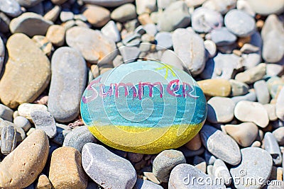 On a pebble beach, the sea is painted in watercolor. The inscription Summer on the sea stone Stock Photo