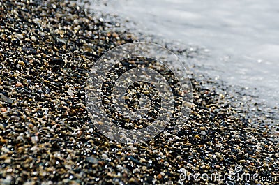 pebble beach washed by sea waves, small and various stones forming the shore Stock Photo