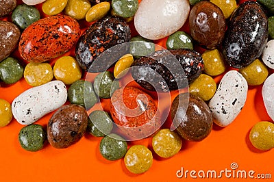 Pebble-dragee with apricots, chocolate, mandarin and marzipan. Tasty, bright, shot on an orange background Stock Photo