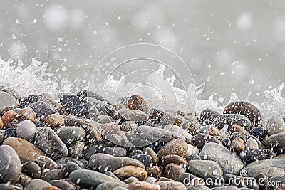 Pebble gravel stones sea water splash defocused bokeh lights nature background. Natural beach stones background Stock Photo