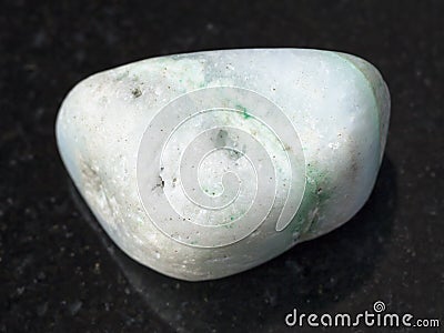 pebble of green Aragonite gemstone on dark Stock Photo