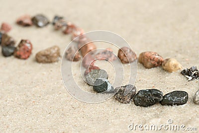 Pebble infinity symbol on sand selective focus Stock Photo