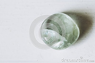 Pebble tumbled polished green fluorite stone on a white background Stock Photo