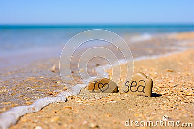 Pebbles with the inscription I love the sea on the beach by the sea. Stock Photo