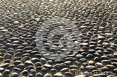 Pebbles mosaic in the sun casting shadows Stock Photo