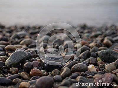 Pebbles on the seashore close-up. Rocky beach. Stones close-up with bokeh. Gray natural background. Autumn on the seashore Stock Photo