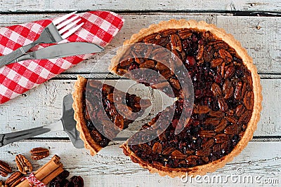 Pecan cranberry pie table scene with slice being removed Stock Photo