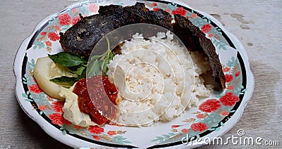 Pecel Lele. It's usually contains rice with side dishes of fried catfish, chili sauce and vegetables. Indonesian food. Stock Photo