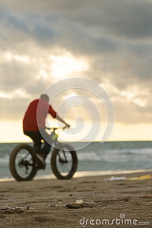 pedaling on the beach against the sun Stock Photo