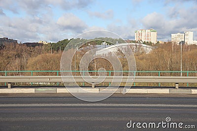 The pedestal and railing of the overpass across the highway against the backdrop of a busy highway, traffic, urbanism. Stock Photo
