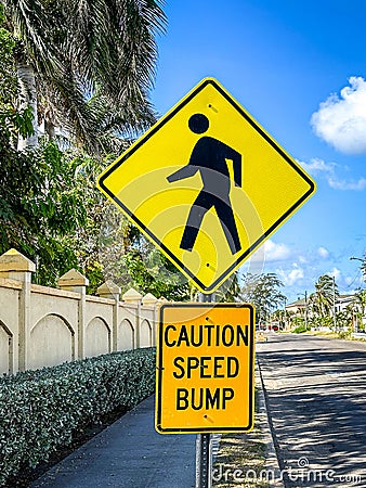 Pedestrian and caution speed bump sign in a tropical setting. Stock Photo