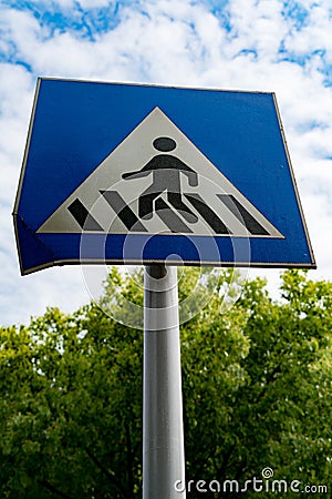 Pedestrian sign or crosswalk sign with blue sky and green tree Stock Photo