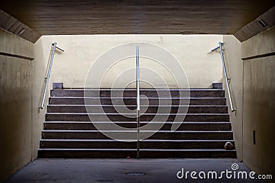 Pedestrian tunnel walkway with stairs light at end Stock Photo