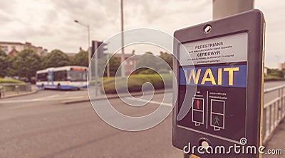 Pedestrian Wait Sign at Pelican crossing in both English and Welsh languages B Stock Photo