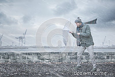 Pedestrian with an umbrella is facing strong wind and rain Stock Photo