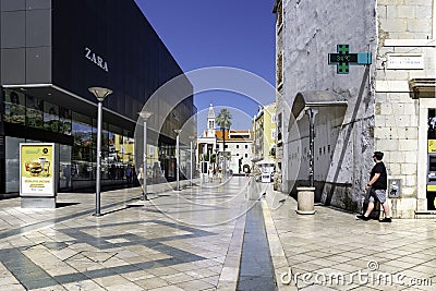 Pedestrian walks down a street with modern shops. Split, Croatia. Editorial Stock Photo