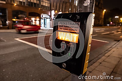 Pedestrian zebra crossing with a system showing the wait warning in English Editorial Stock Photo
