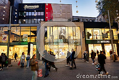 pedestrians in front of illuminated stores in cologne Editorial Stock Photo