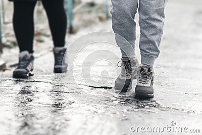 Pedestrians glide along the icy sidewalk. Winter ice on footpaths Stock Photo