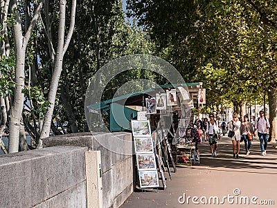 Pedestrians walk past book stalls along the Seine Editorial Stock Photo