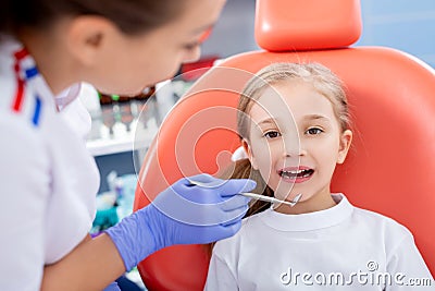 Pediatric dentist checks caries in a little girl. beautiful girl is smiling in dentist`s office. concept is a children`s medical Stock Photo