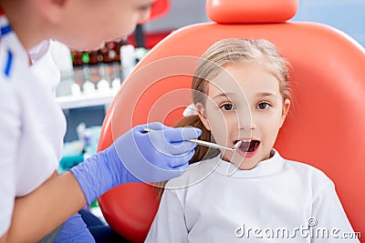 Pediatric dentist checks caries in a little girl. beautiful girl is smiling in dentist`s office. concept is a children`s medical Stock Photo