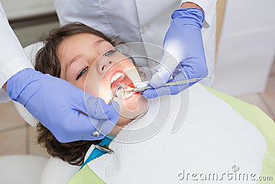 Pediatric dentist examining a little boys teeth in the dentists chair Stock Photo