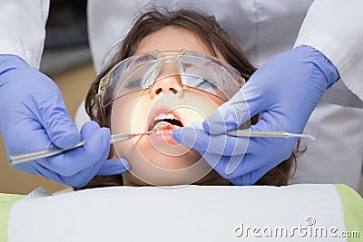 Pediatric dentist examining a little boys teeth in the dentists chair Stock Photo