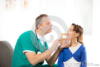 Pediatrician checking little girl throat Stock Photo