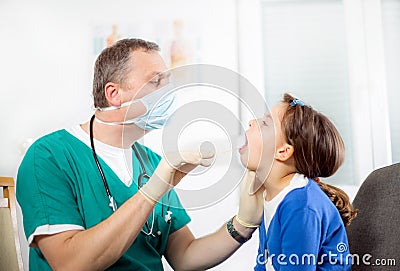 Pediatrician checking little girl throat Stock Photo