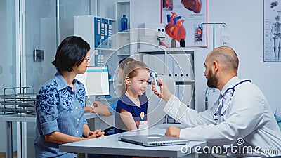 Pediatrician checking ontemperature Stock Photo