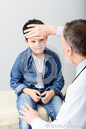 Pediatrician checking temperature of sick patient Stock Photo