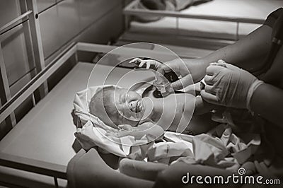 A pediatrician examines a child in the clinic, a newborn girl is lying on the table.Black and white photo Stock Photo