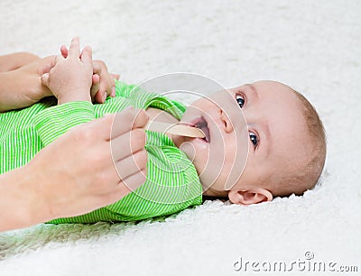 Pediatrician examines a newborn baby with a spatula Stock Photo