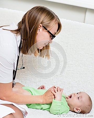 Pediatrician examines a newborn baby with a spatula Stock Photo