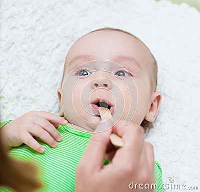 Pediatrician examines a newborn baby with a spatula Stock Photo