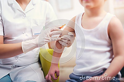 Pediatrician makes vaccination to boy Stock Photo