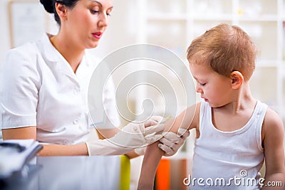 Pediatrician makes vaccination to little boy Stock Photo