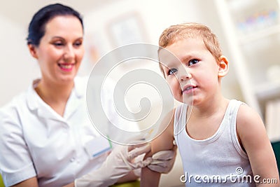 Pediatrician makes vaccination to small boy Stock Photo