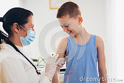Pediatrician makes vaccination to small boy. Stock Photo