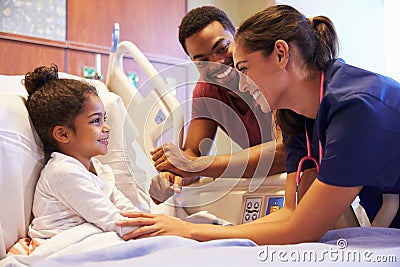 Pediatrician Visiting Father And Child In Hospital Bed Stock Photo