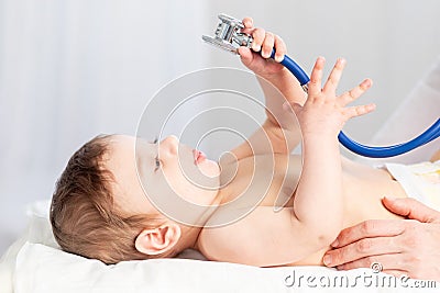 Pediatrics, a doctor examines a baby boy and uses a stethoscope to listen to the child`s breathing, the concept of medicine and Stock Photo