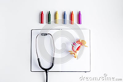 Pediatrics equipment with crayons, copybook white background top view space for text Stock Photo