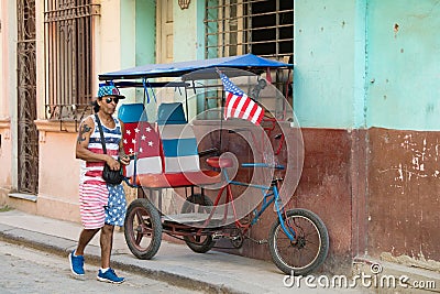 Pedicab, bikecab, velotaxi, cycle with flag of USA and seats , drivers shirt, cap, shorts with stars and stripes, Havana, Cuba. Editorial Stock Photo